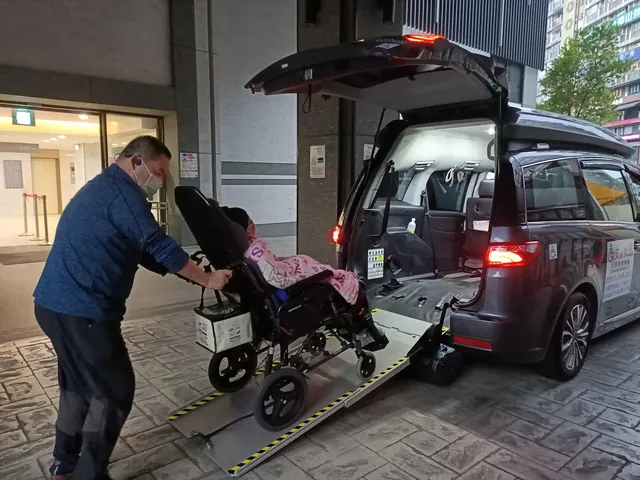 工作人員把高背輪椅沿著斜板推上無障礙車